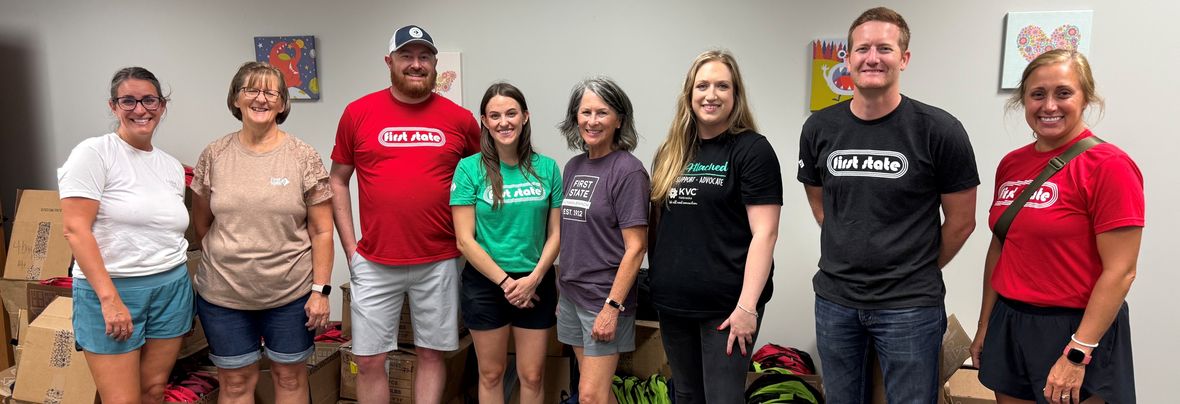 a group of volunteers delivering backpacks