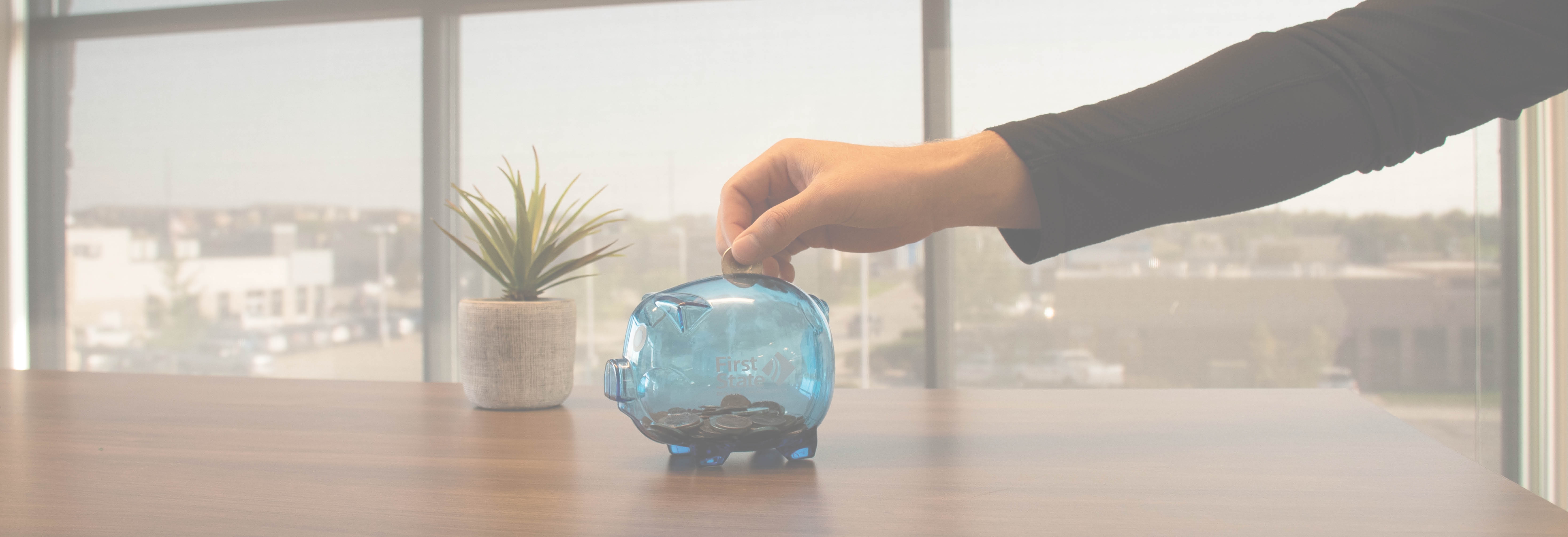 Person putting quarter into piggy bank