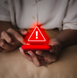 person holding phone with red alert