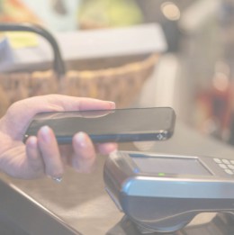 Person paying at register with mobile phone