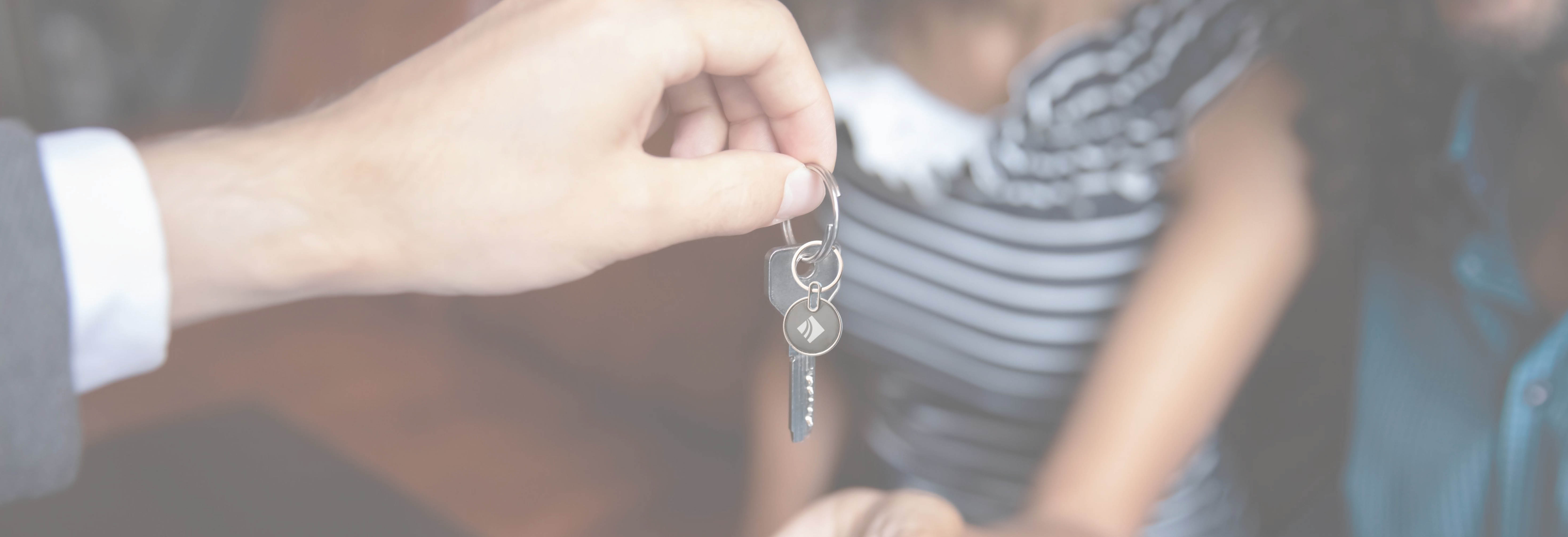 Person handing new homebuyers their keys