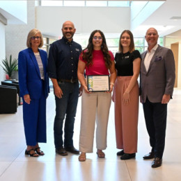 five people standing in a line holding a certificate