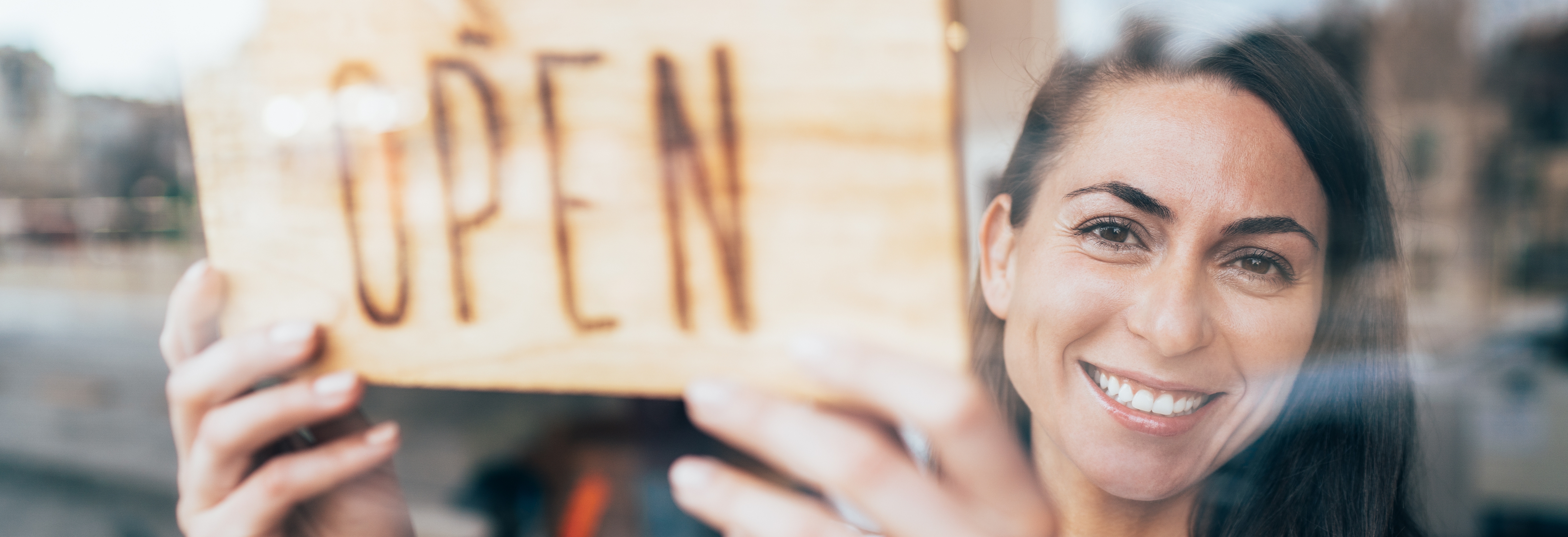 Small business owner hanging open sign