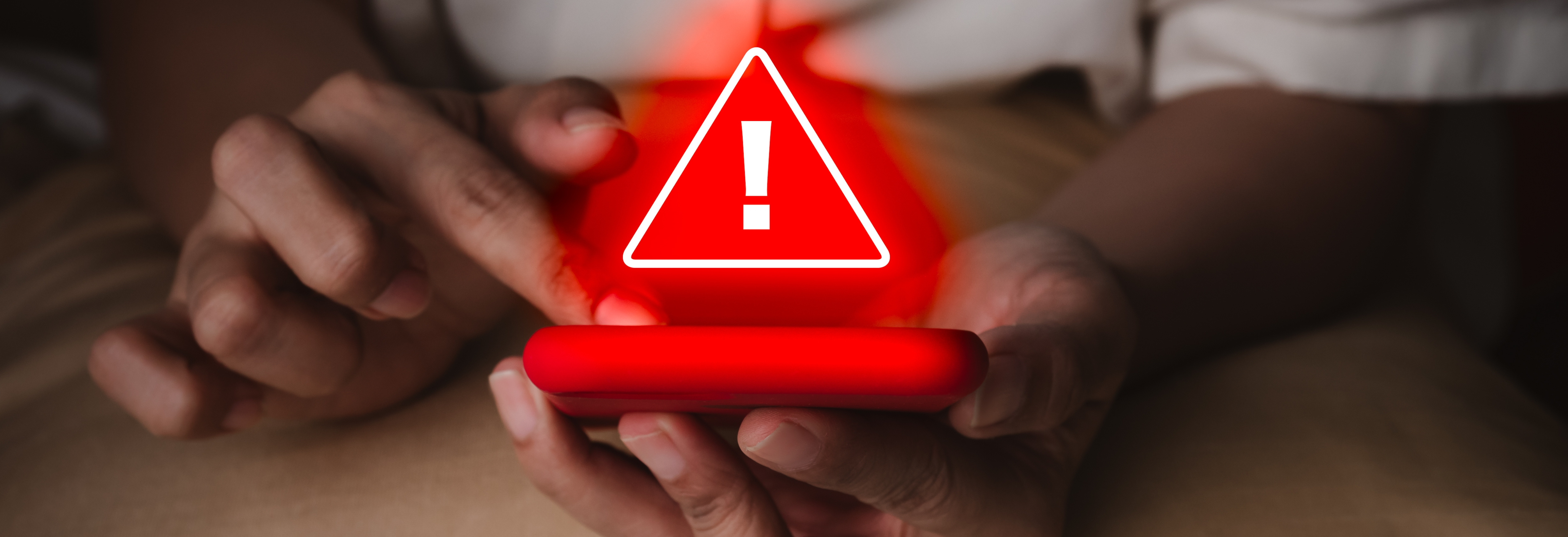 person holding phone with red alert
