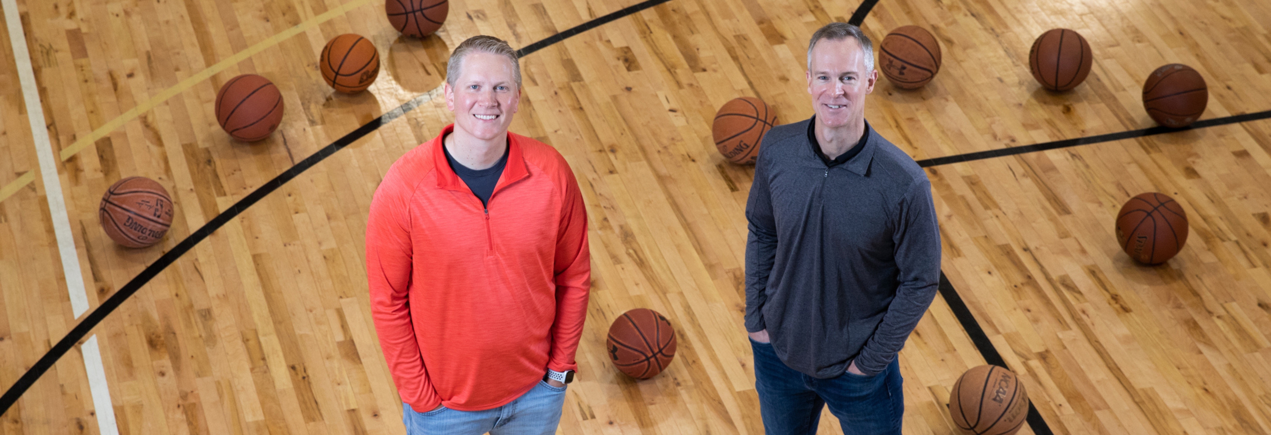 two men standing on a basketball court