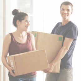 Young couple moving boxes into new home