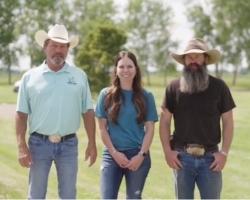 two men in cowboy hats and a women smiling outside