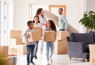 family carrying boxes into a house