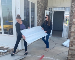 two women holding a large light
