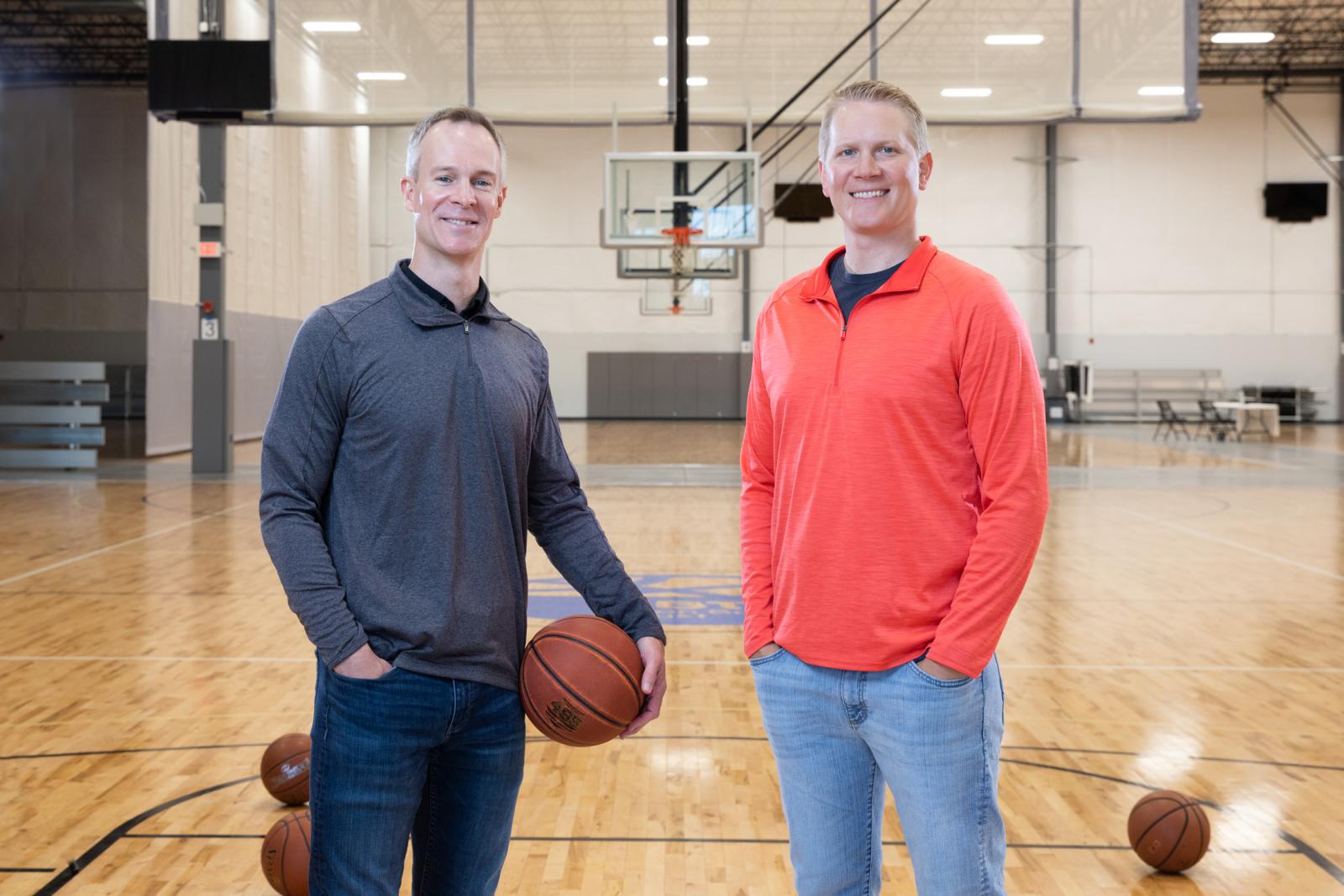 two men standing on a basketball court